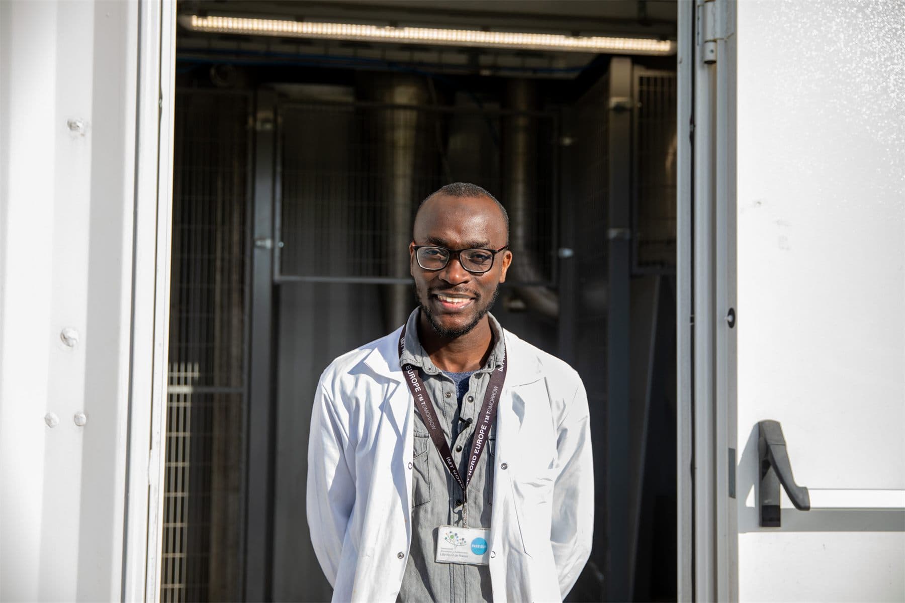 Dr. Mouhamadou Amar en blouse devant l'unité pilote
